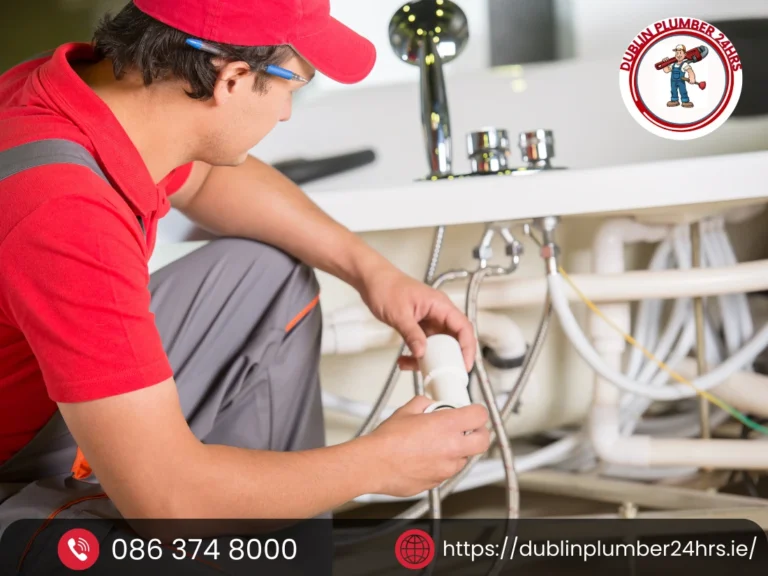 Experienced plumber South Dublin fixing a leaking pipe beneath a kitchen sink during a home plumbing repair